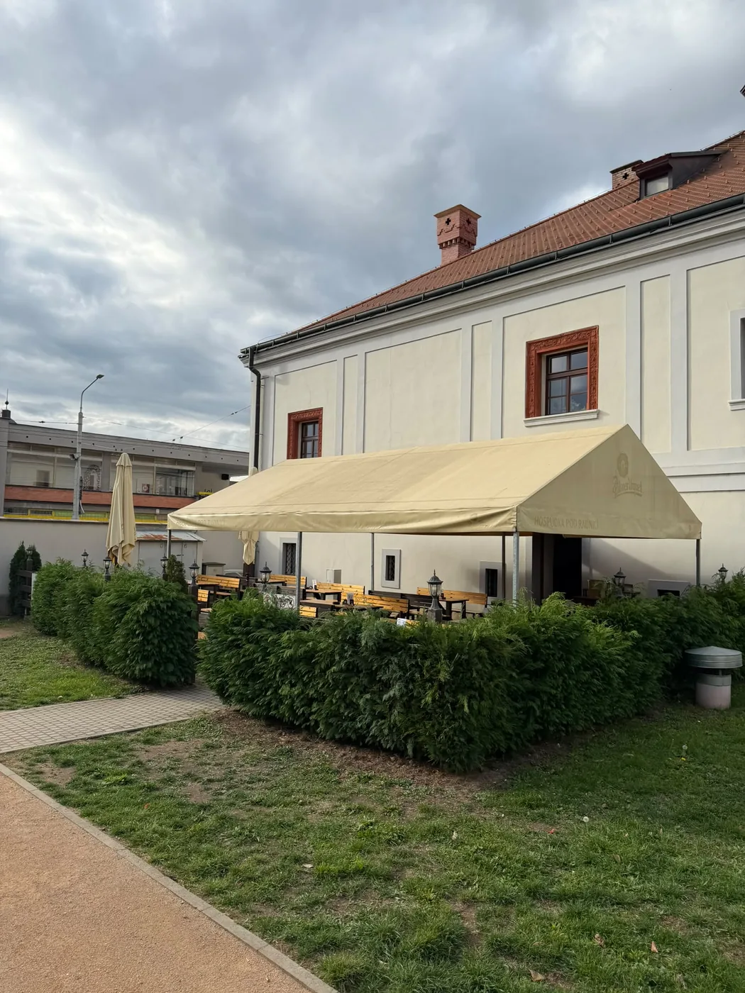 Zahrádka pod plachtou Pilsner Urquell vedle budovy